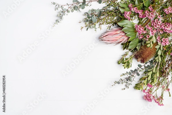 Obraz Beautiful fresh floral flat-lay arrangement of Australian native Eucalyptus leaves, pink Protea, purple Banksia and pink Wax-flowers, on a rustic white background. Space for copy