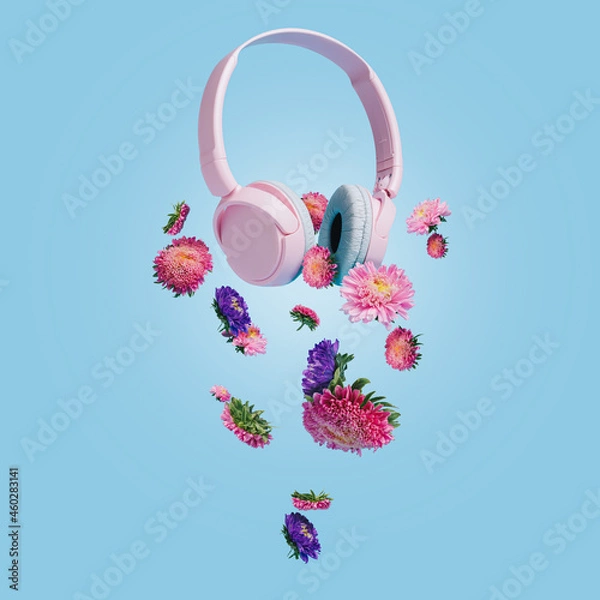 Obraz Pink headphones with lilac and violet Gerbera flowers flying against bright blue background. Colorful floral spring arrangement. Stereo sound and music. Creative music or flower bloom concept.