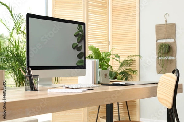 Fototapeta Comfortable workplace with computer in light room. Interior design