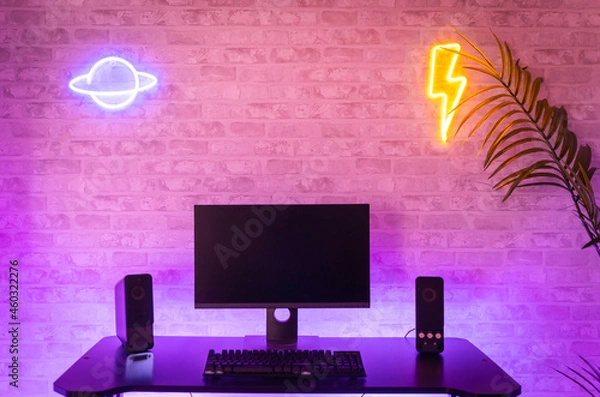 Fototapeta Computer gamer workspace with black screen monitor with neons and colorful lights. Gamer Rig.