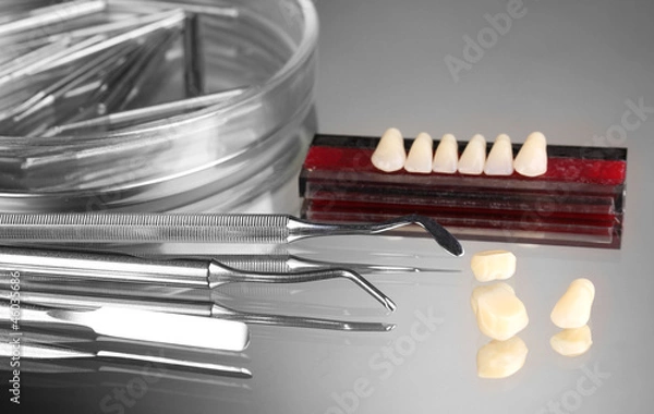 Fototapeta Set of dental tools with denture on grey background