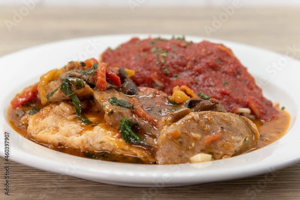 Fototapeta Double chicken breast served with spaghetti with marinara sauce as pollo campagnola