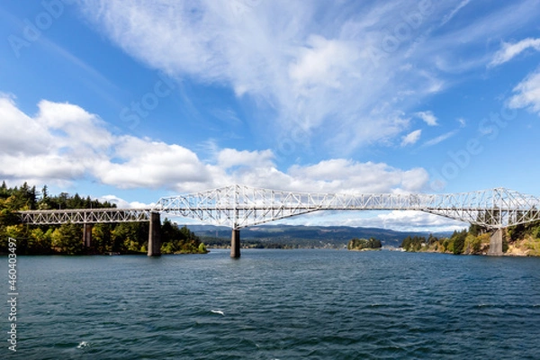 Obraz Panoramic wide view of the Bridge of the Gods, in Cascade Locks, Oregon, overlooking the Columbia River on a beautiful and breezy, wispy white cloud, blue sky afternoon.