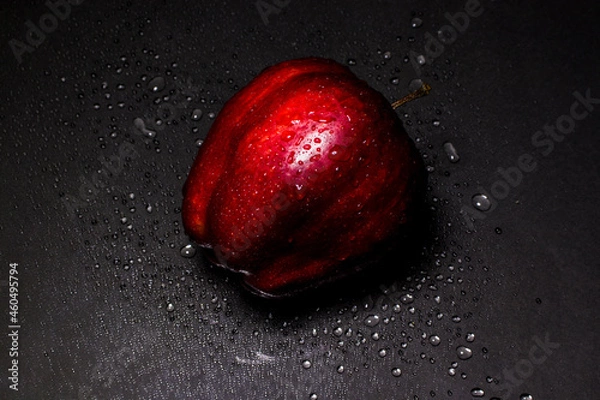 Obraz fresh red apple with droplets of water against black background