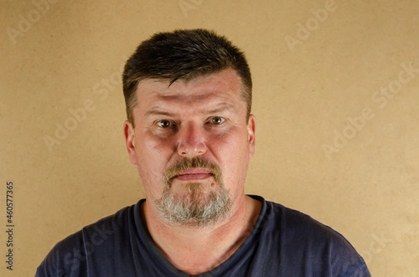Fototapeta Portrait of a 45-year-old man looking at the camera. Adult unshaven male indoors.