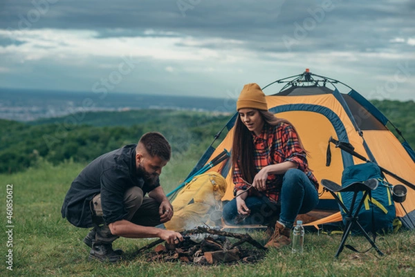 Fototapeta Campers lighting up a camp fire while camping in the nature
