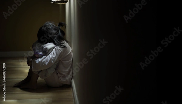 Fototapeta Squat single child sit near window, sad lonely in dark night indoor, crying, bad mood, offended, consoles,  concept of unhappy childhood, life together