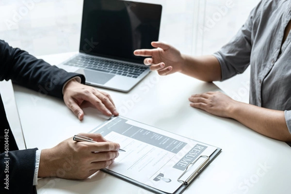 Fototapeta Businessman interview consider a resume conversation during about profile of candidate of conducting a job interview listen to answers while sitting at the working meeting in office