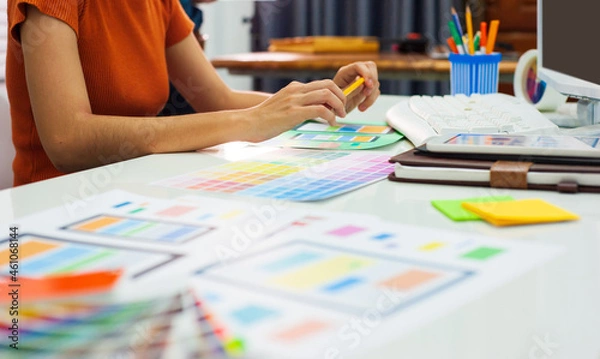 Fototapeta Web designers are working on computers on their desks in the office.