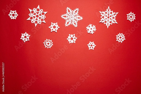 Fototapeta Christmas decoration with white paper snowflakes on red