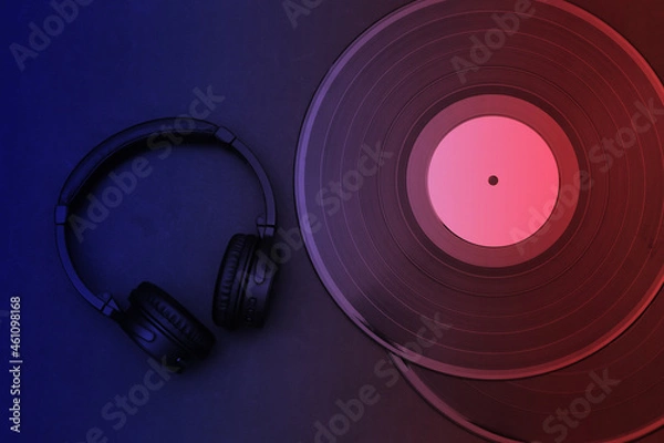 Fototapeta Retro vinyl records and headphones in blue red neon light. Top view