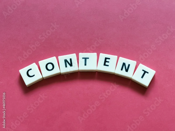 Fototapeta Word CONTENT center placed lettering created using square letter tiles isolated on red background.