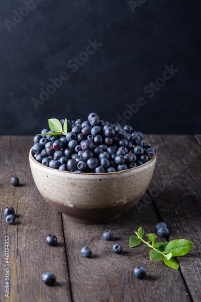 Fototapeta Blueberry bowl on wooden background with copy space in rustic style