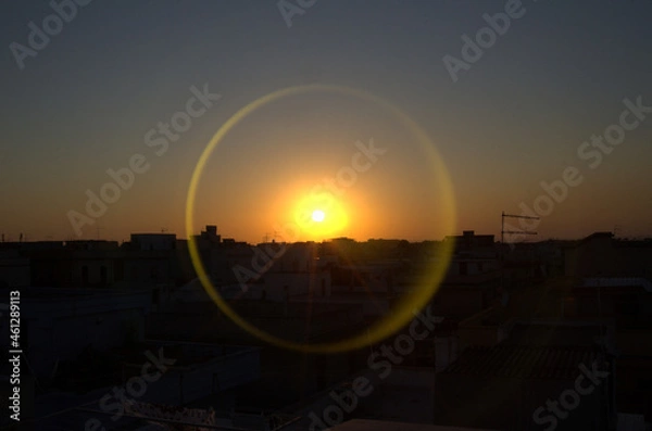 Obraz Fotografia di un tramonto con alone circolare riflesso.