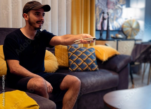 Obraz Boy using tv remote in living room