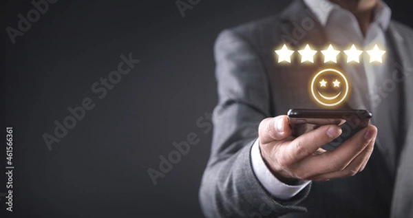 Fototapeta Man holding smiling face and five stars. Feedback. Customer satisfaction