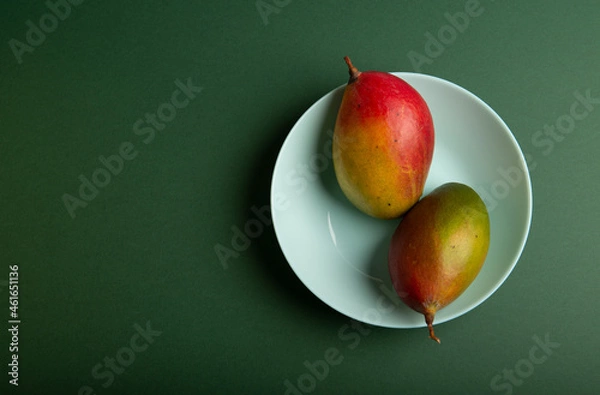 Obraz Two mango on green table with plate