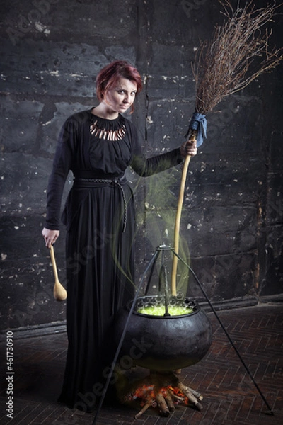 Fototapeta Young beautiful witch preparing a potion for Halloween 