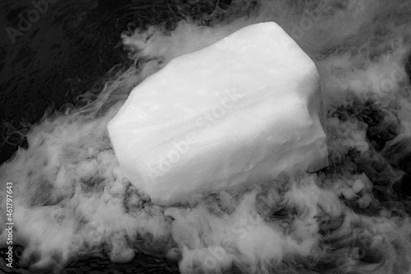 Obraz Dry ice evaporates in the water. Steam from a large piece of ice. Chemical experiment.