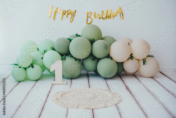 Fototapeta Card. Stylish photo zone in light colors with balloons and a wooden number one and the inscription Happy Birthday. Light background white wood floor. Сake smash concept.