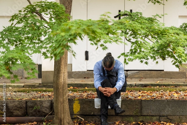 Fototapeta 勤務に疲れ境内で仮眠をとる中年の勤め人