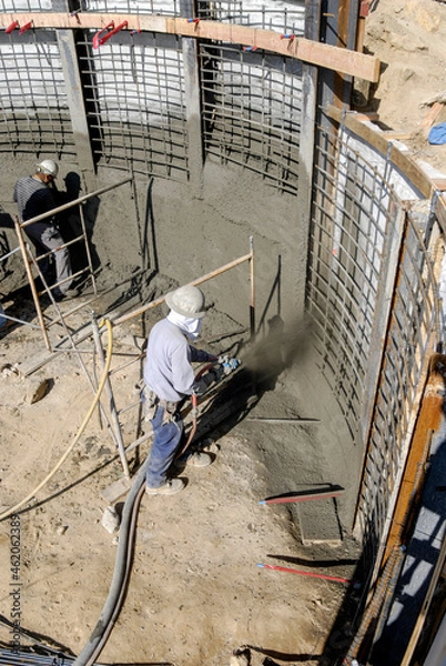 Fototapeta Shotcrete specialists shooting forms for a new retaining wall