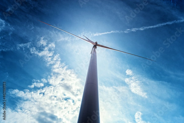 Obraz Wind power turbines in the countryside in a sunny day in agricultural field with blue sky and white clouds in summer
