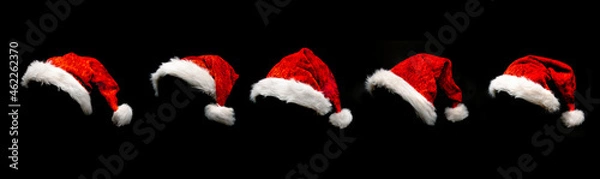 Obraz Rote Weihnachtsmützen isoliert vor schwarzem hintergrund