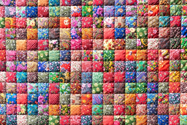 Fototapeta Traditional stylized handmade patchwork cover with bright colorful geometric flower patterns created for sale as vintage background
