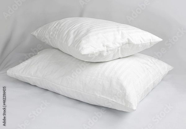 Obraz Two white pillows in striped cotton pillowcases. Satin jacquard bedding and accessories. Air soft pillows filled with swan down and bamboo