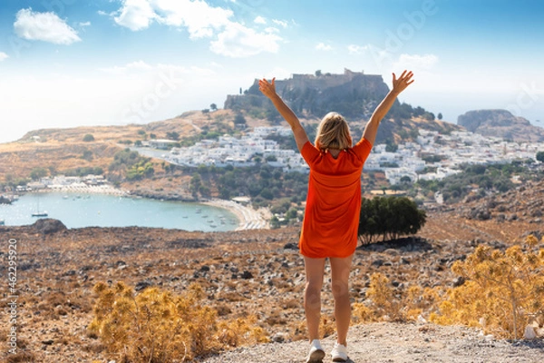 Obraz A blonde woman looks at the panorama of Lindos on the island of Rhodes, Greece