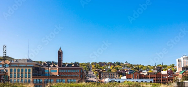 Fototapeta Panoramic view of downtown in autumn season with clear blue sky, view of transportation from the hill to the city. Daytime sightseeing of buildings and nature landscape. Skyline scenic with copy space