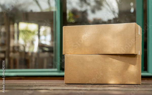 Fototapeta cardboard boxes delivered to the forn door and left outside for contactless pickup, delivery for online shopping, contact-free delivery and pickup due to COVID-19. High quality photo