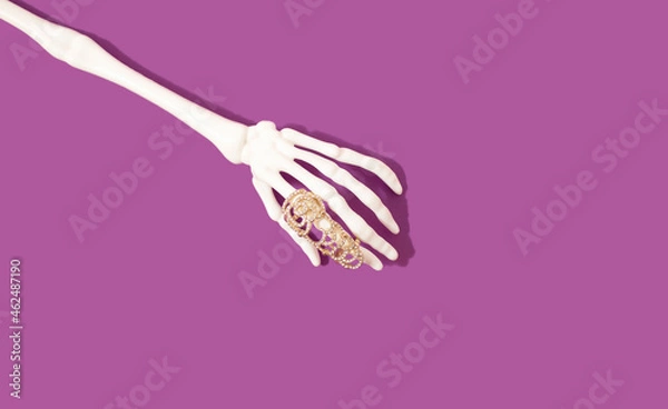 Obraz Skeleton hand with beauty ring on violet background. Bizarre concept.