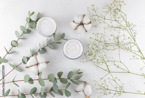 Fototapeta cream on white background with eucalyptus and cotton flower