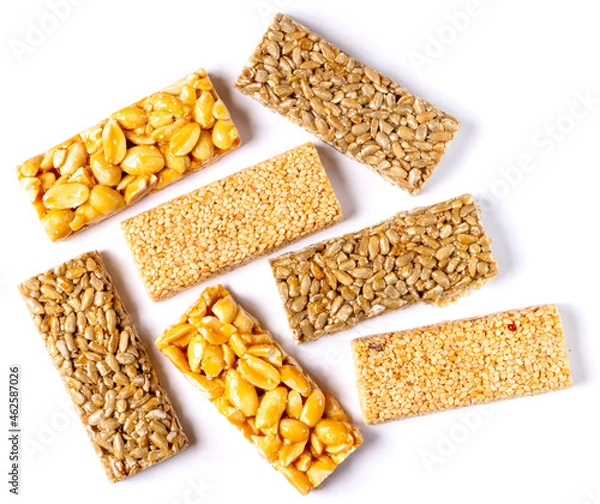 Fototapeta Rectangular pieces of kozinak - sunflower, peanut and sesame seeds. Isolated on white background. Close-up. Top view.
