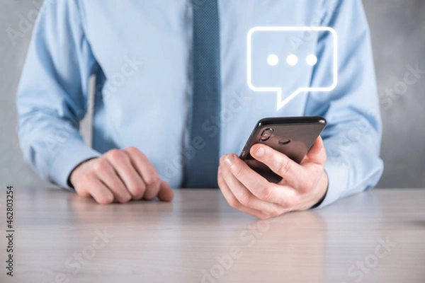 Fototapeta Businessman holding a message icon, bubble talk notification sign in his hands. Chat icon, sms icon, comments icon, speech bubbles