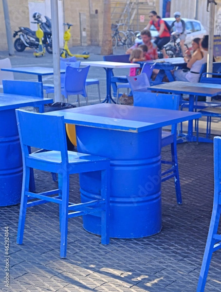 Obraz Street cafe in the port of Old Jaffa in Tel Aviv. The furniture is painted bright blue and  tables are made from old fuel barrels.