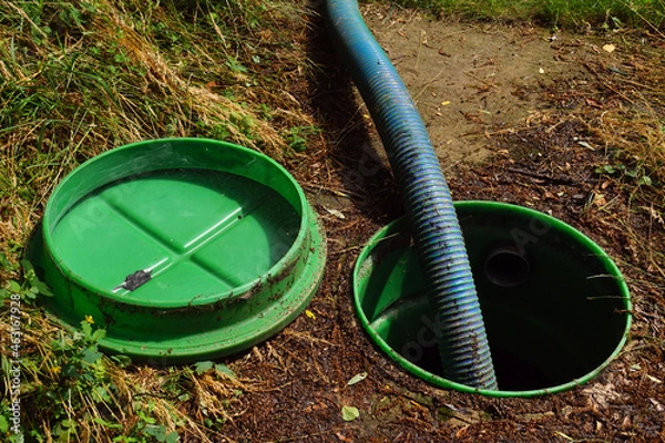 Fototapeta Pumping out sewage from a septic tank. Pipe in the drainage pit.