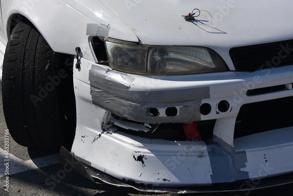 Fototapeta car after the accident. cracked headlight without turn signal. Broken bumper repaired with gray tape