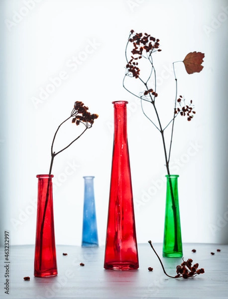 Obraz COLORED glass vases on a white table