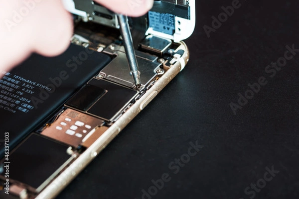 Fototapeta Close-up with the repair of a used smartphone with a screwdriver