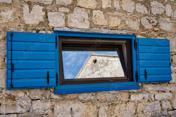 Obraz reflections in a lonely blue window in the wall