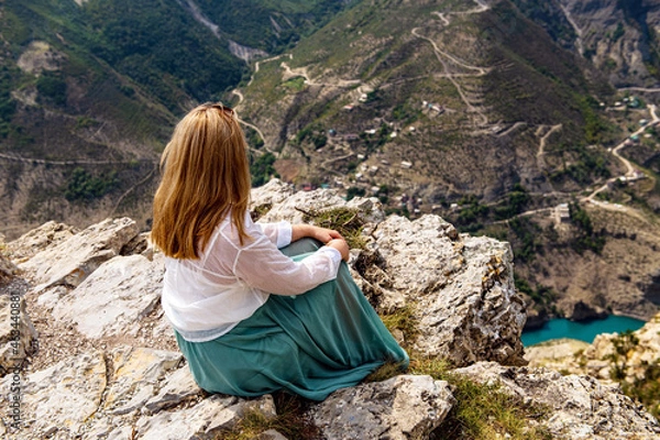 Fototapeta A girl sitting on a rock on a cliff in Sulak canyon, Dagestan