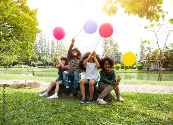 Obraz Group of diverse children are playing colorful balloons in the park.
