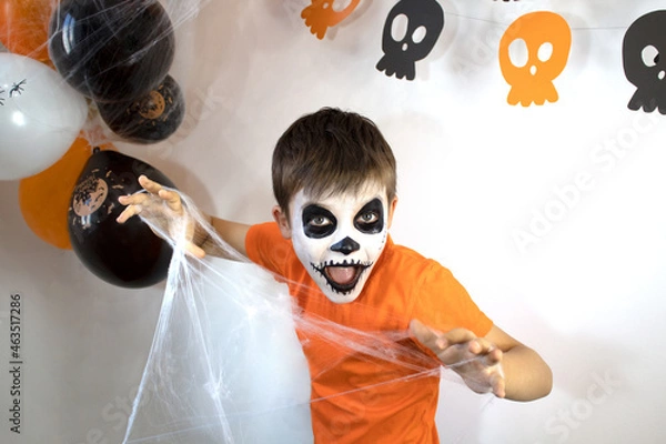 Obraz Happy baby with skeleton makeup. Spider web in the hands of a boy on Halloween