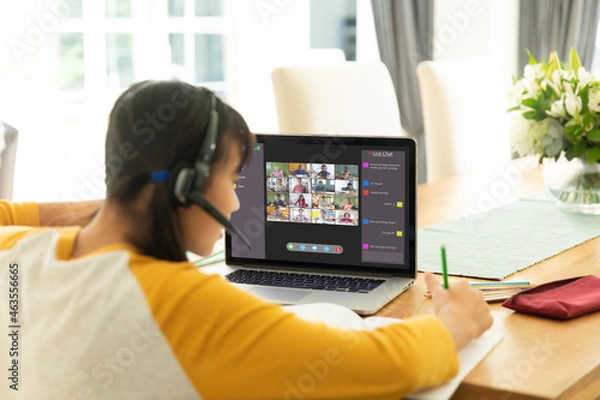 Fototapeta Asian girl using laptop for video call, with smiling diverse elementary school pupils on screen