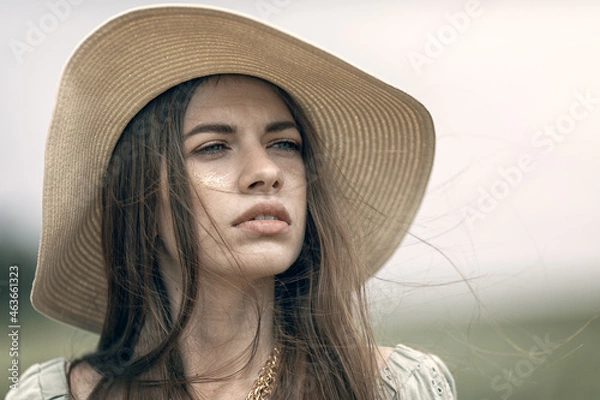 Obraz a woman in a hat looks into the distance portrait close-up