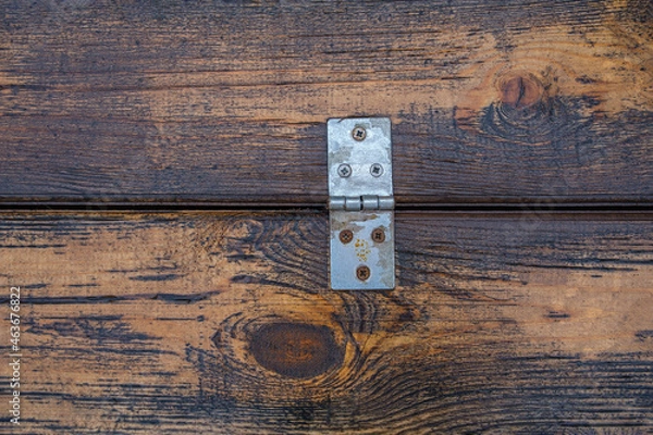 Obraz an old silver door hinge on wet varnished boards is fixed with rusty screws