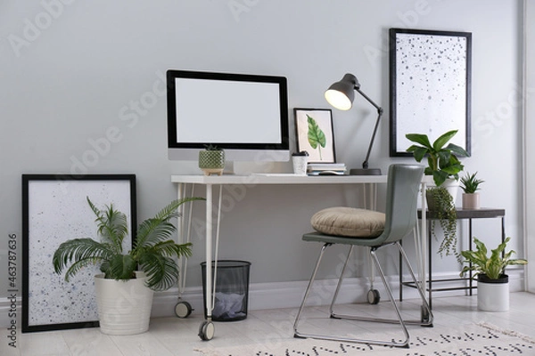 Fototapeta Comfortable workplace with modern computer and houseplants in room. Interior design